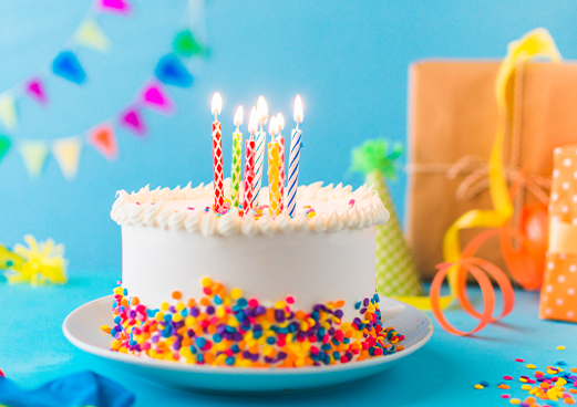 decorative-cake-with-burning-candle-blue-background